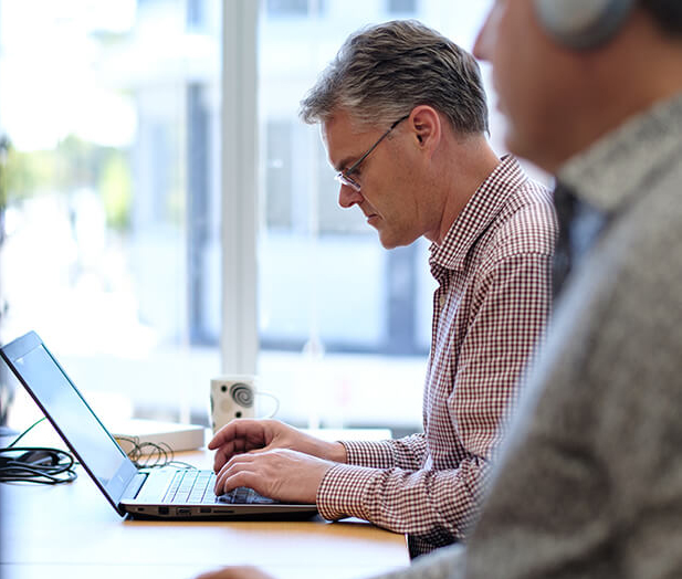 hero - An Office 365 consultant working on a business strategy on his laptop in an office