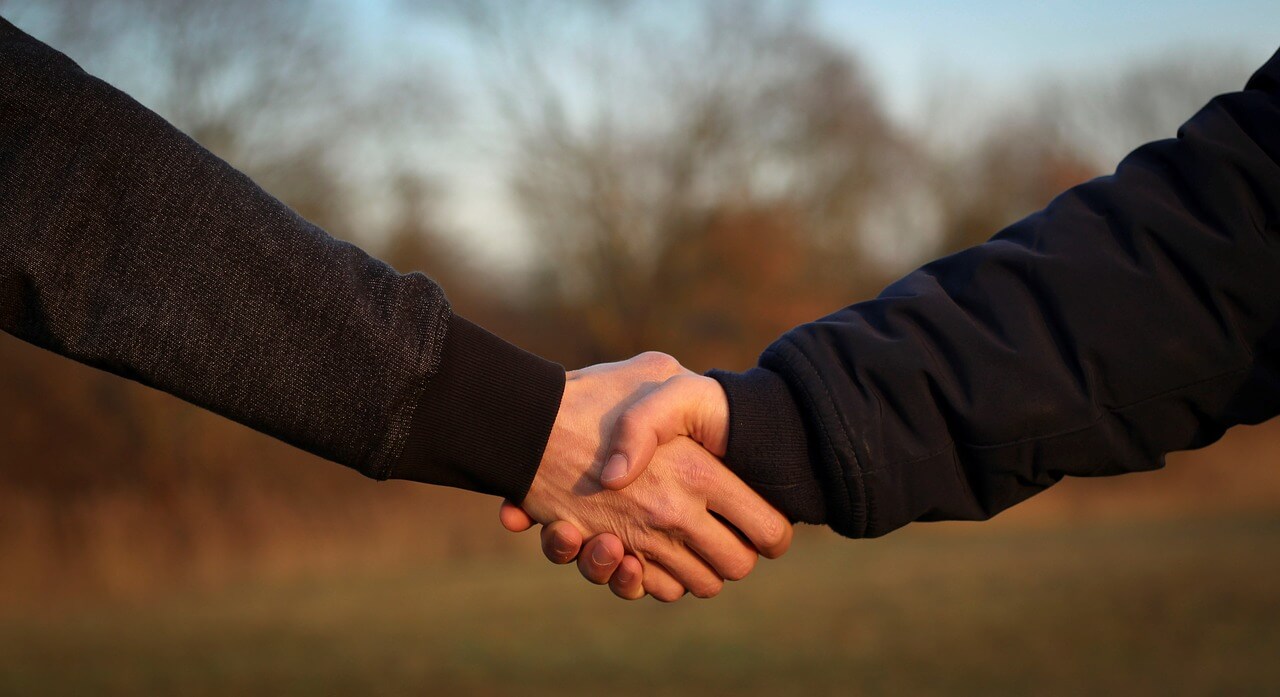 news - A close up of two hands shaking, representing ALGIM and Information Leadership