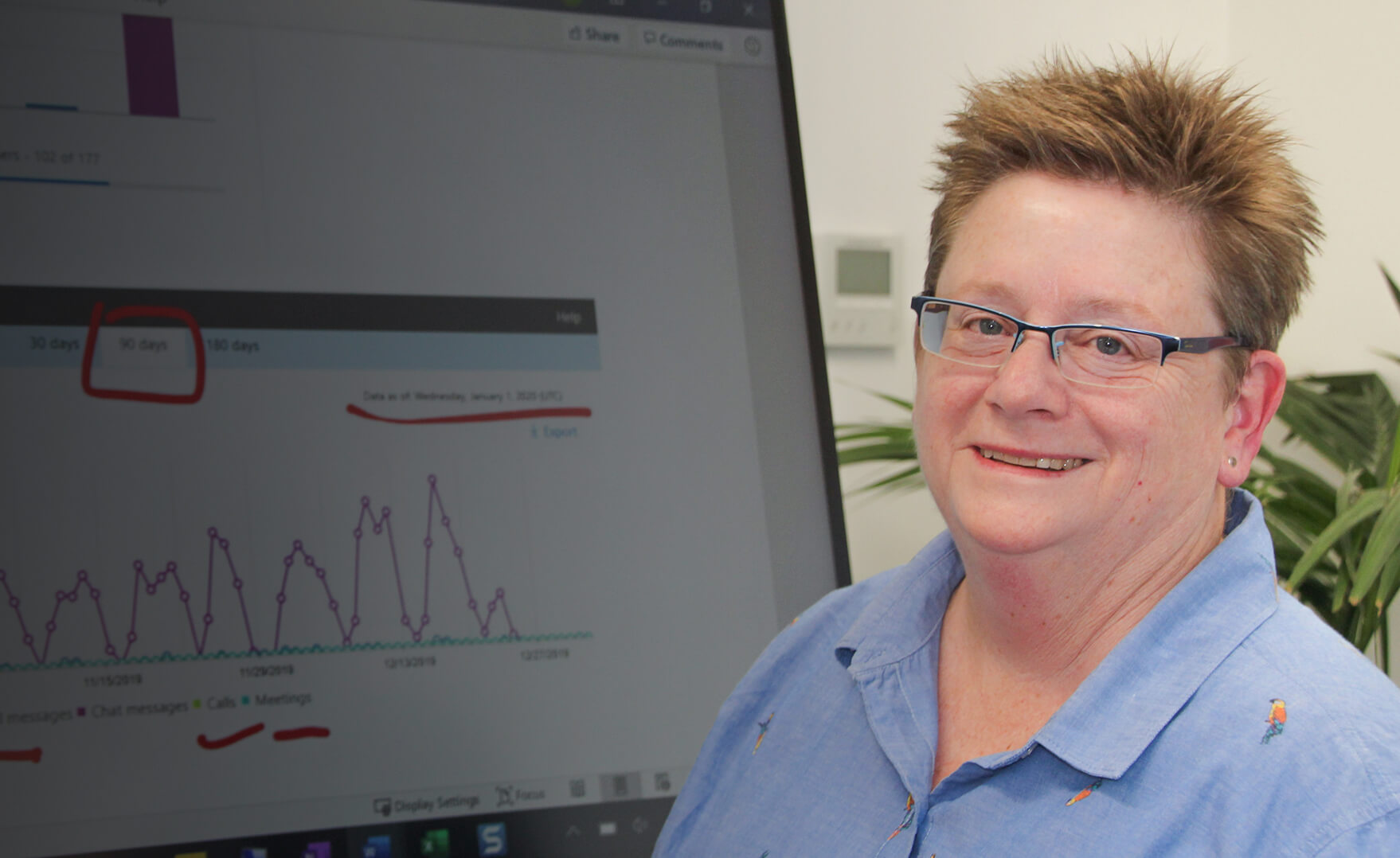 news shadow - A smiling Office 365 consultant stands in front of a Microsoft Surface Hub with a SLA displayed on it