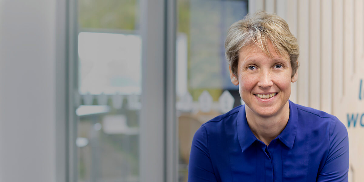 news shadow - Sarah Heal, Information Leadership's director, standing in a New Zealand office and smiling