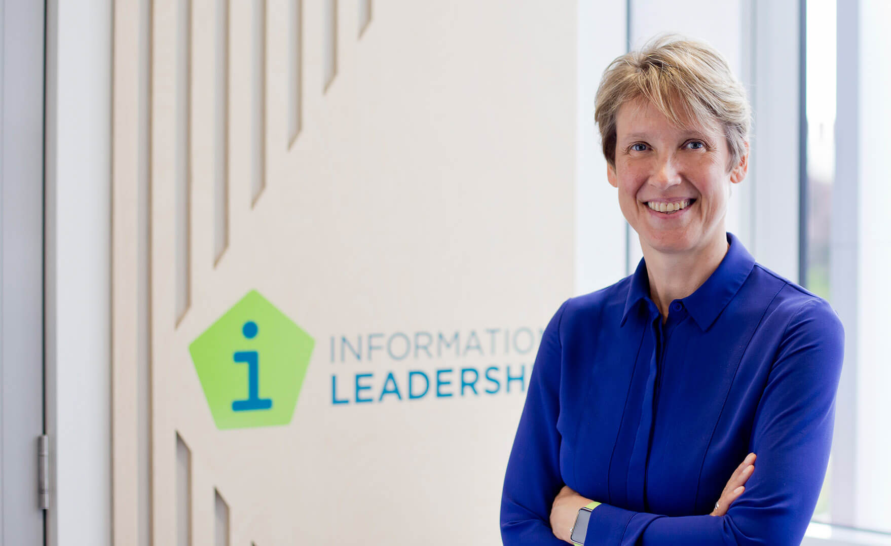 news - Sarah Heal, Information Leadership's director, standing in a New Zealand office and smiling